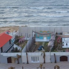 A photography studio pictured from above with a view over the sea