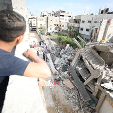 A child looks out over a destroyed house