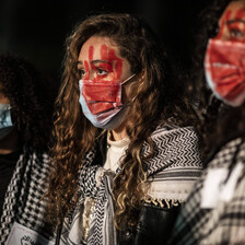 Three women with their faces painted blood red