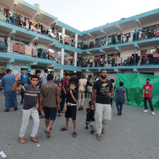 A number of people stand in the yard of a crowded school in southern Gaza
