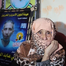 Gaza woman Suad al-Amour sits beside a photographic tribute to her late son Sami