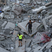 Two Palestinian children stand on rubble in al-Zahra in Gaza