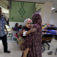 A girl holds tight to a woman in a Gaza hospital 
