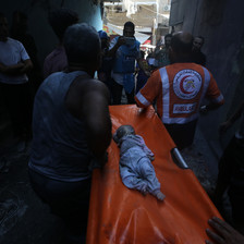 paramedics carry a stretcher with the body of a baby