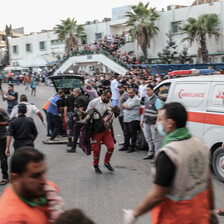 A medic carries an injured child beside the entrance to al-Shifa hospital in Gaza City