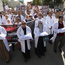 A street protest of doctors carrying props of infants in body bags
