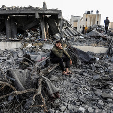 A man sits in what remains of a home following an Israeli attack 