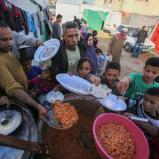 Children and a few adults queue for food in Gaza 