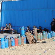 A few men stand beside a row of cooking gas cylinders in southern Gaza 