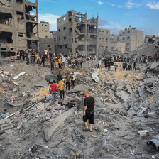 People walk in and search through the rubble of Jabaliya refugee camp after it was attacked by Israel 