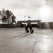 Two people walk across an empty courtyard