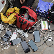 On the ground, a tangle of cellphones charging