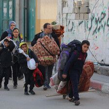 A family carry their belongings after being ordered to evacuate their home 