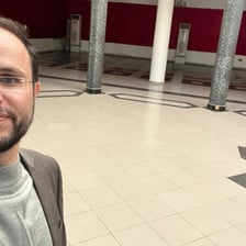 A man takes a selfie in an empty hall