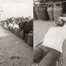 A row of gas canisters stretches into the distance, and a man lying on the ground next to the canisters