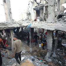 A man walks past a house destroyed in a missile attack