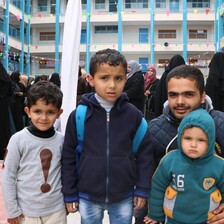 A father poses with three children in the courtyard of a school