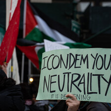 A protest sign reads: I condemn you neutrality