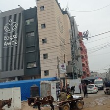 A number of people walk outside al-Awda hospital in central Gaza 