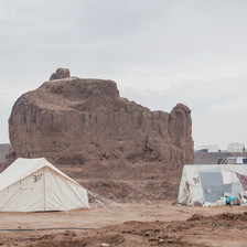 Two tents in the foreground of a desert landscape