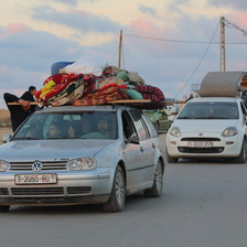 Cars and vans with many items packed on their roofs 