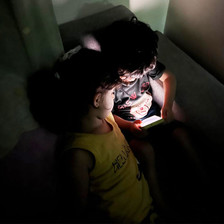 two children huddle together around a phone