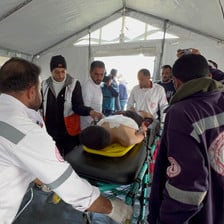 Medics in a Gaza tent attend to a patient on a stretcher 