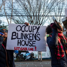 Protestors hold a sign reading: Occupy Blinken's house