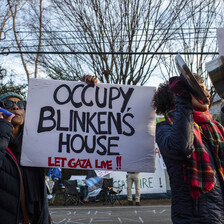 Protestors hold a sign reading: Occupy Blinken's house