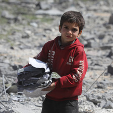 A boy stands amid the remains of a building that has been destroyed by Israel 