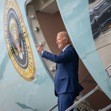 US President Joe Biden stands and waves at the door of Air Force One