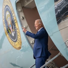US President Joe Biden stands and waves at the door of Air Force One 