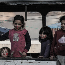 Four children play in the wreckage of a bus