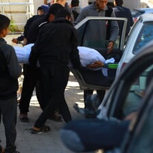 A dead body is carried by a number of people following an Israeli massacre in Gaza 