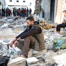 A man sits amid the rubble in Rafah 