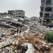 Two people walk amid rubble toward the remains of buildings which have been attacked in Gaza City 