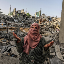 A woman stands in the middle of a home that has been destroyed in southern Gaza 