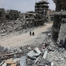 Two people walk through a scene of utter destruction in southern Gaza 
