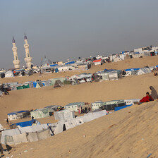 A daytime view of tents erected along a sandy desert hillside