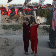 two girls walk between decorated tents