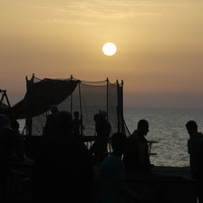 People beside the shore as it gets dark 