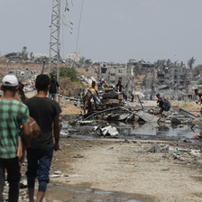 A few people can be seen amid a badly damaged refugee camp in central Gaza 