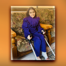 A portrait of a girl sitting down and holding crutches 