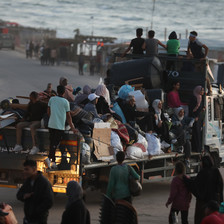 families on the back of a truck with their possessions