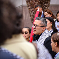 A man speaks in a crowd of people