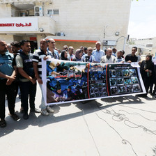 Journalists hold up a banner depicting their slain colleagues