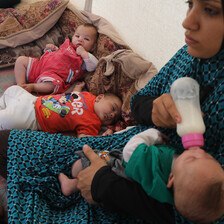 A mother feeds her baby milk