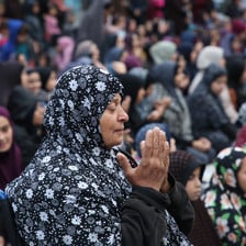 A crowd of women pray 