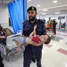 An emergency worker carries wounded child