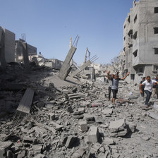 People walk in the rubble following an Israeli massacre in central Gaza 